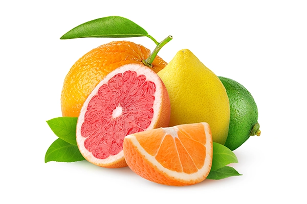 Grupa świeżych owoców cytrusowych, w tym cała pomarańcza z liściem, pokrojony grejpfrut, cytryna, limonka i kawałek pomarańczy, wszystkie ułożone na białym tle z kilkoma zielonymi liśćmi.