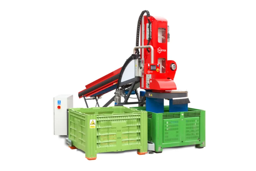 A red industrial robot is positioned above two large green plastic crates, with a control panel nearby, all against a white background.