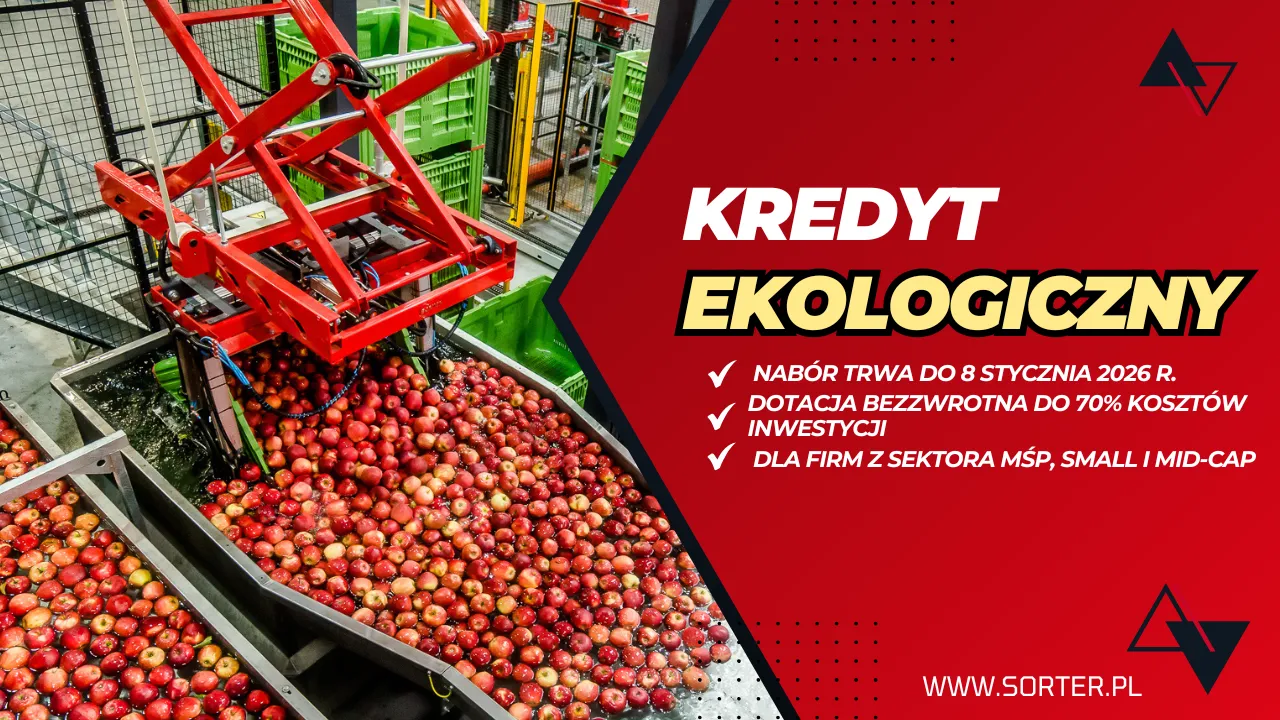 Maszyna sortuje czerwone jabłka na przenośniku taśmowym w fabryce. Obok czerwony baner reklamuje przyjazną dla środowiska pożyczkę dla małych i średnich firm, wspominając o dotacjach do 70% kosztów inwestycji i terminie do 8 stycznia 2026 roku.
